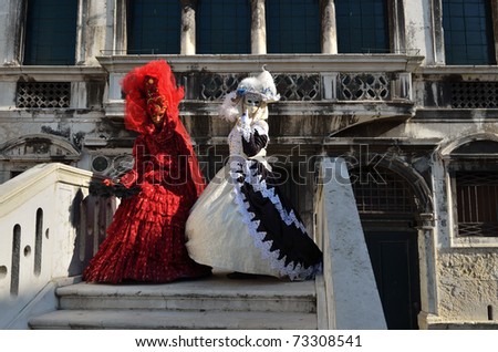 VENICE - MARCH 7: Two unidentified masked person in costume on the bridge via Venice canal during the Carnival on March 7, 2011. The 2011 carnival was held from February 26th to March 8th.
