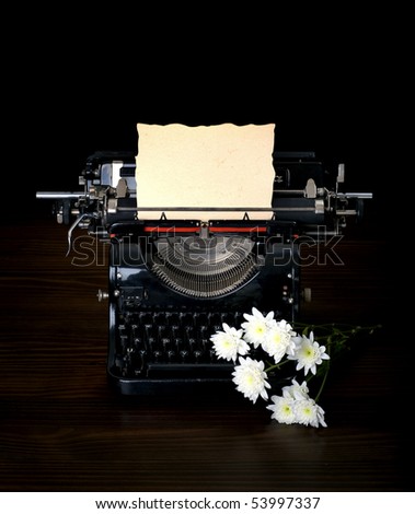 antique typing machine with paper for text  and flowers