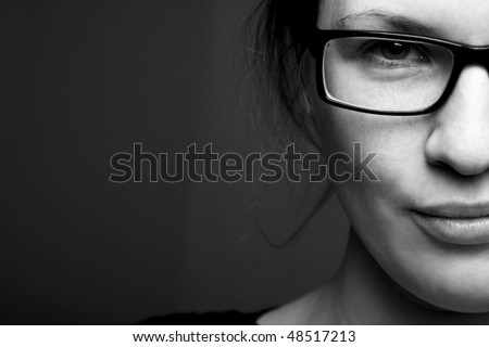Beautiful half face woman in glasess llooks into the camera
