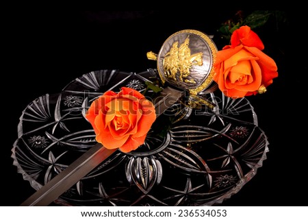 Cutlass and roses isolated over a black background