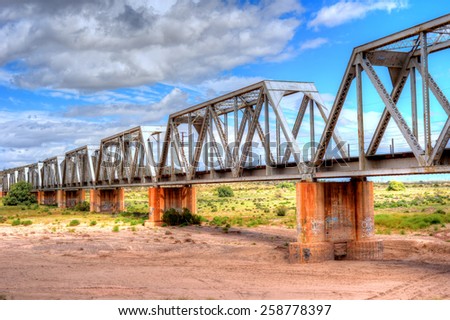 Iron railroad bridge over dry river bed