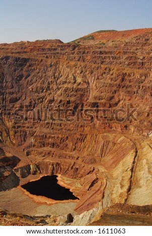 Open pit mine with stagnant pond at bottom