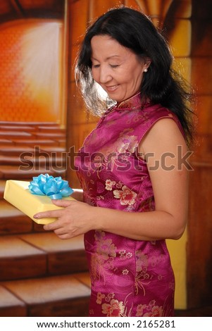 Sexy asian lady wearing a traditional dress holding gift