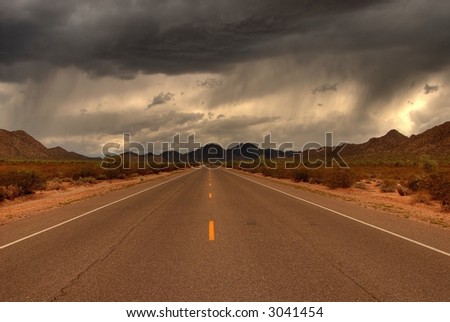 Dramatic desert mountain road with a storm approaching
