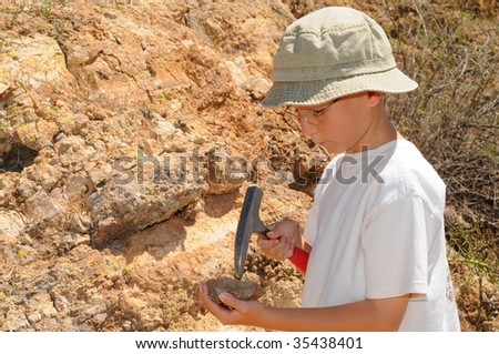 Young boy studying geology out in the field