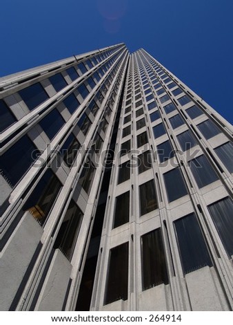 Looking up a skyscraper to blue sky.