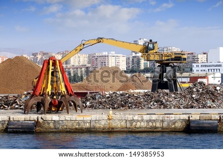 Crane working with scrap metal stored in port