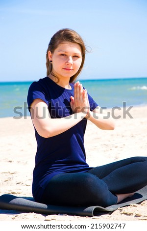 Mental health. Young woman practicing yoga at sea.