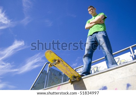 Sport conceptual image.  Teenage skateboarder standing on the ramp with skateboard.