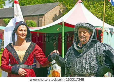 TATTON PARK, ENGLAND - JUNE 15: Senior man and young woman in medieval costume participants at The Medieval Fayre one of the most popular annual events of the Tatton Park in Cheshire, 15, June 2013.