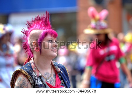 MANCHESTER - AUGUST 27: Girl participant with shaved pink hair, tattoos and piercings at Manchester Pride annual event on the 27th of August, 2011 in Central Manchester, UK