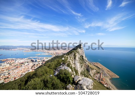 Gibraltar Rock view from above, on the left Gibraltar town and bay, La Linea town in Spain at the far end, Mediterranean Sea on the right.