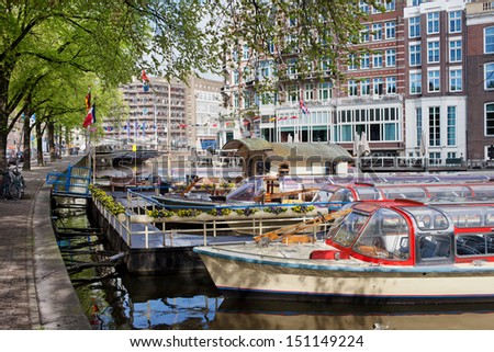 Canal cruise boats on the Amstel river in Amsterdam, Netherlands, North Holland province.