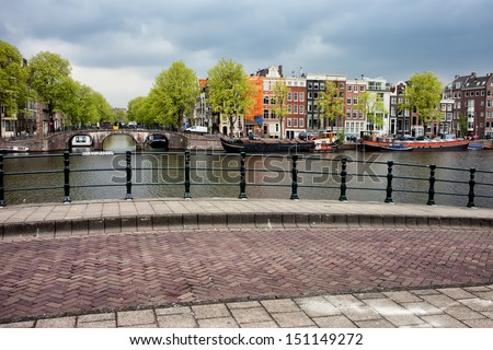 City of Amsterdam, view from the Jan Vinckbrug bridge on historic houses by the Amstel river in Netherlands, North Holland province.