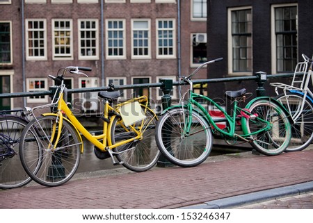 Vintage bikes on a bridge sidewalk in the Old Town of Amsterdam in Netherlands.