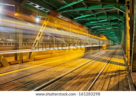 Abstract tram light trail in the lower part of the steel truss Gdanski Bridge in Warsaw, Poland, vanishing point perspective.