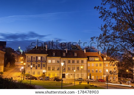 Terraced tenement houses at night in the New Town, Warsaw, Poland.