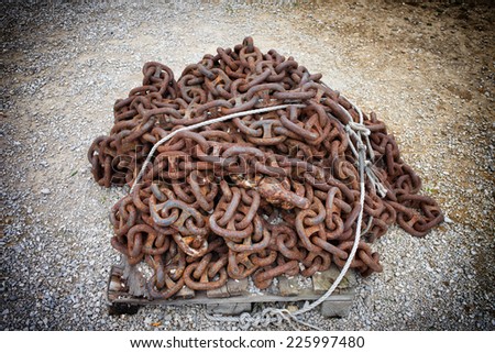 Pile of an old, long, vintage, rusty metal chain with large links.