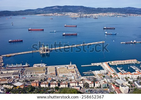 Gibraltar quay from above, Algeciras city in Spain on the horizon, cargo ships on bay waters