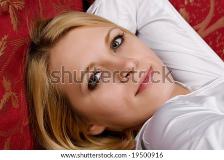 Isolated portrait of pretty young woman, laying on the sofa.