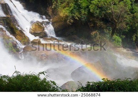 Rainbow over the waterfall in tropical forest.