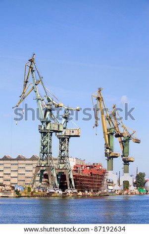 Industrial scenery, huge shipyard cranes and ship under construction