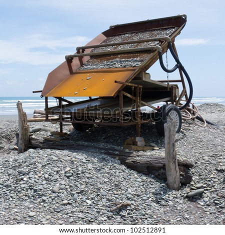 Metal sluice box on placer mining claim for extracting alluvial gold dust from gravel beach of West Coast of New Zealand South Island