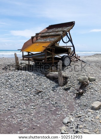 Metal sluice box on placer mining claim for extracting alluvial gold dust from gravel beach of West Coast of New Zealand South Island
