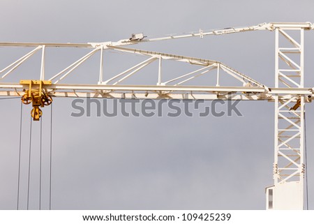 Detail abstract of old rusty steel construction crane for hoisting heavy loads during building construction and development