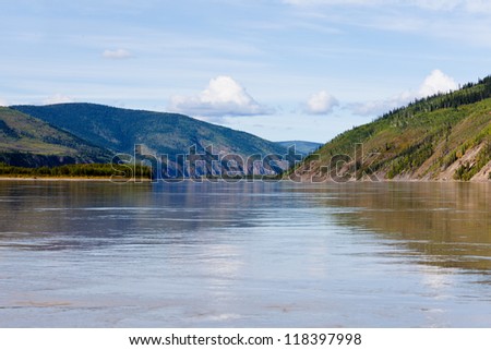 Boreal forest hills at river bank of Yukon River, Yukon Territory, Canada, near Dawson City forming a beautiful northern riverscape.