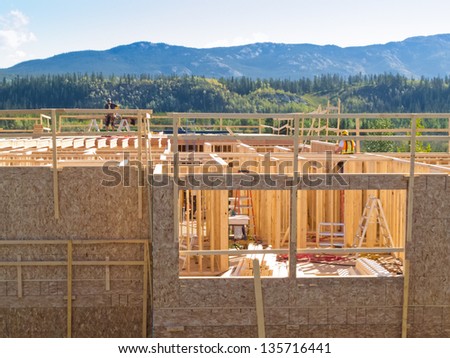 Urban development concept  new build rural house under construction with view of wooden framework interior will block out beautiful wilderness landscape scenery in background when completed