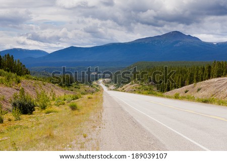 Endless empty road of Alaska Highway, Alcan, crossing wide open expanse boreal forest taiga landscape west of Watson Lake, Yukon Territory, Canada
