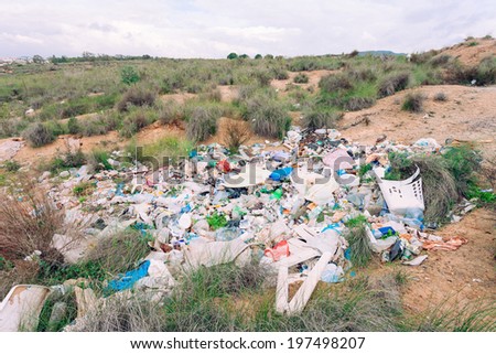 Pile of rubbish illegally dumped in natural landscape polluting nature environment