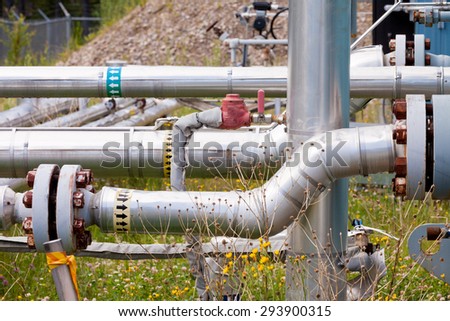 Confusing complex outdoor piping system of shut-down natural gas well installation with rusty bolts