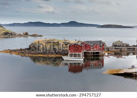 Red painted wooden fishing shacks at New Foundland, NL, Canada, Atlantic Ocean coast calm cove