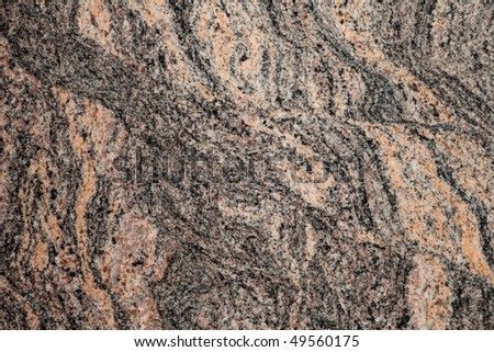 Surface of polished granite slab. Close-up of beautiful natural design of red granite.