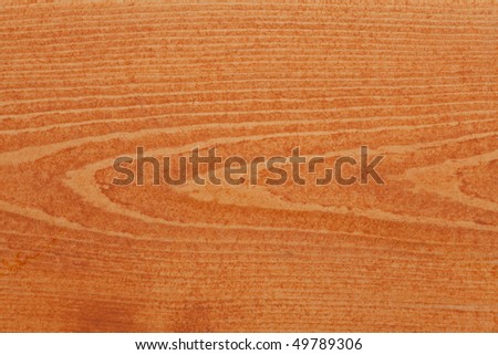 Pine or spruce (softwood) deck board stained with cedar colored transparent deck stain.