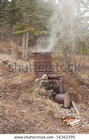 Home-made smoker for preservation of fish and meat by fumigation in action.