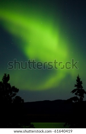 Intense Aurora borealis (northern lights) being mirrored on Lake Laberge, Yukon Territory, Canada.