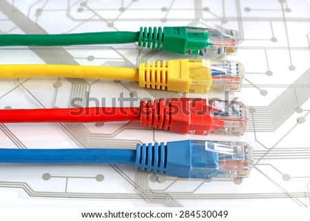 Four Multi Colored Network Cables. Red, Yellow, Green, Blue Color. Cables are lying horizontaly on top of White Circuit Board