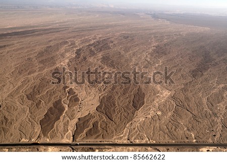 Flight over Nazca lines - Dry river bed aerial view with a road - Peru