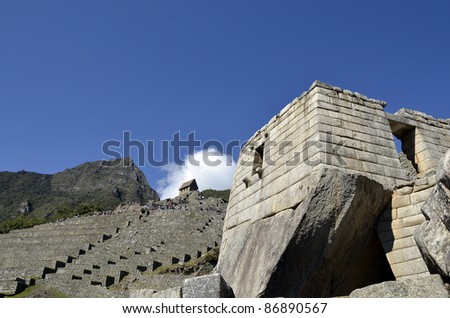 Ancient Inca Sun Temple on Machu Picchu with Terraces and  Blue Sky in the Background