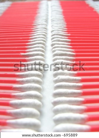 Pink cotton swabs lined up in a neat row