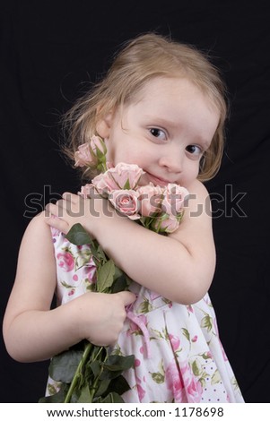 three year old hugging roses