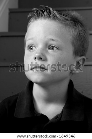 Black and white portrait of a worried boy.