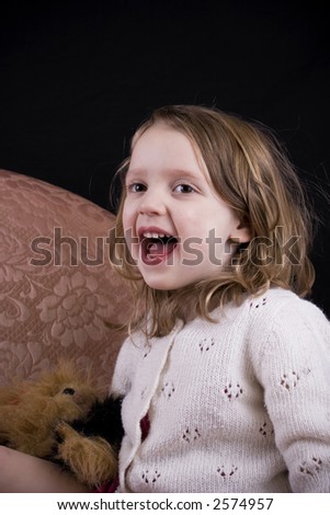 Happy little girl laughing out loud in a close-up portrait.