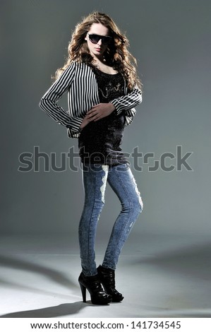 Full length fashion woman studio in jeans on light background