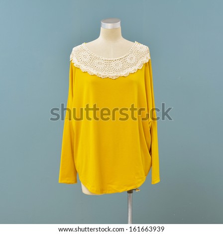 Isolated female yellow clothes on mannequin-blue background