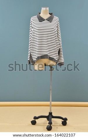 Full length mannequin in female stripy dressed on gray background