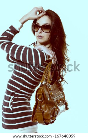Elegant beautiful woman with fanning hairs and sunglasses-light blue background